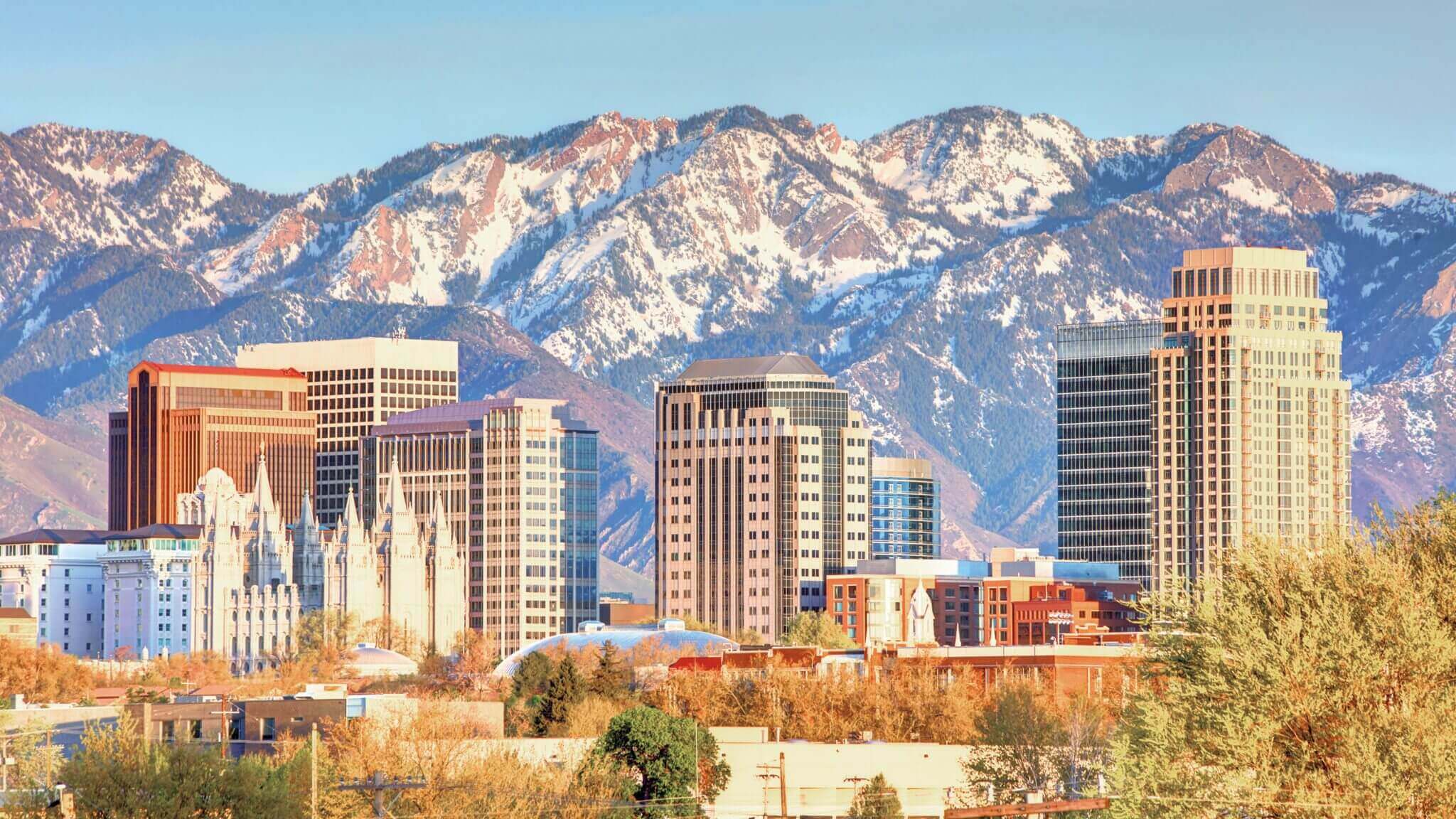 City skyline with mountains in the background during daytime.