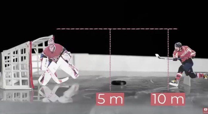 Hockey goalie diving to stop a puck on an ice rink.