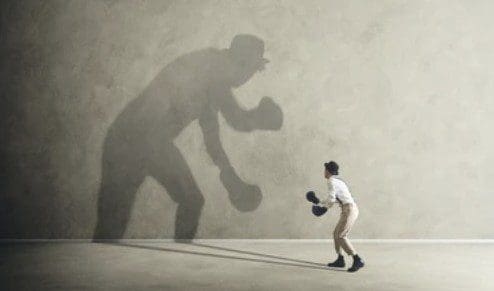 A person shadowboxing with a giant shadow.