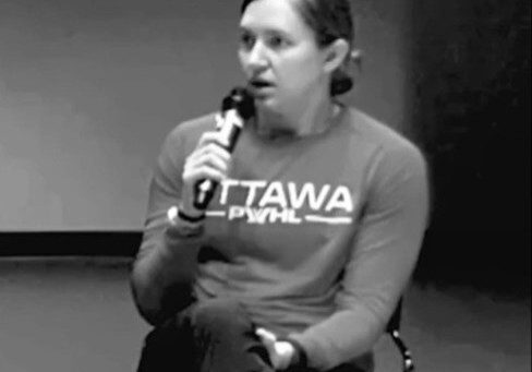 Person speaking into a microphone during an event.
