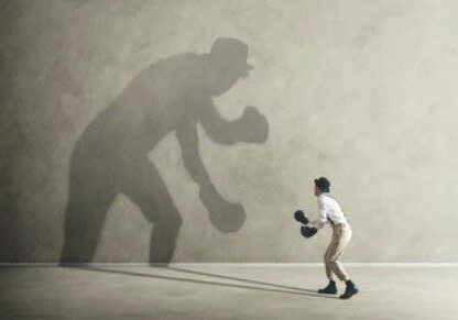 A person shadowboxing with a giant shadow.