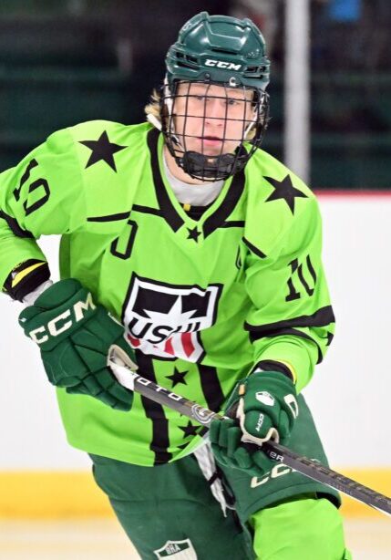 Youth ice hockey player in a bright green jersey mid-game action.