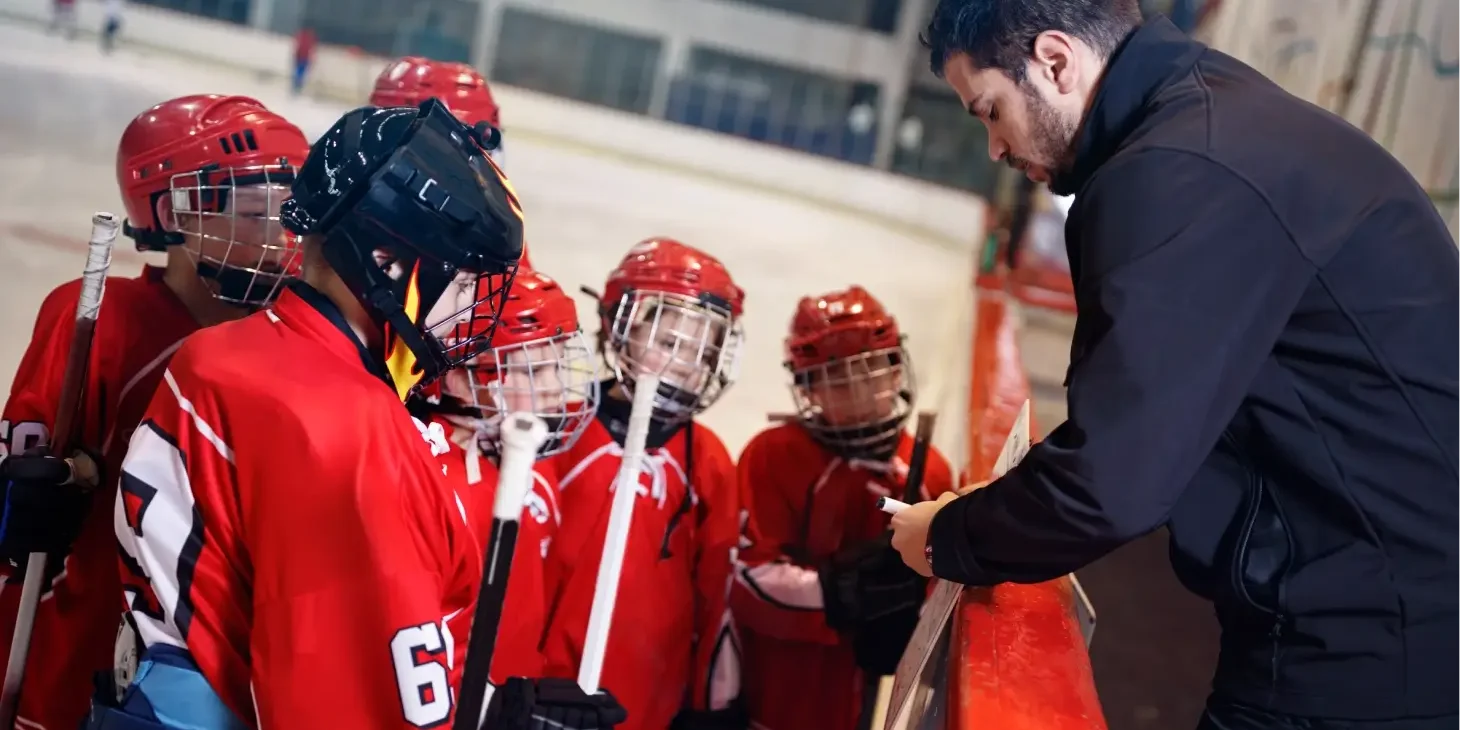 Hockey coach instructing young players.