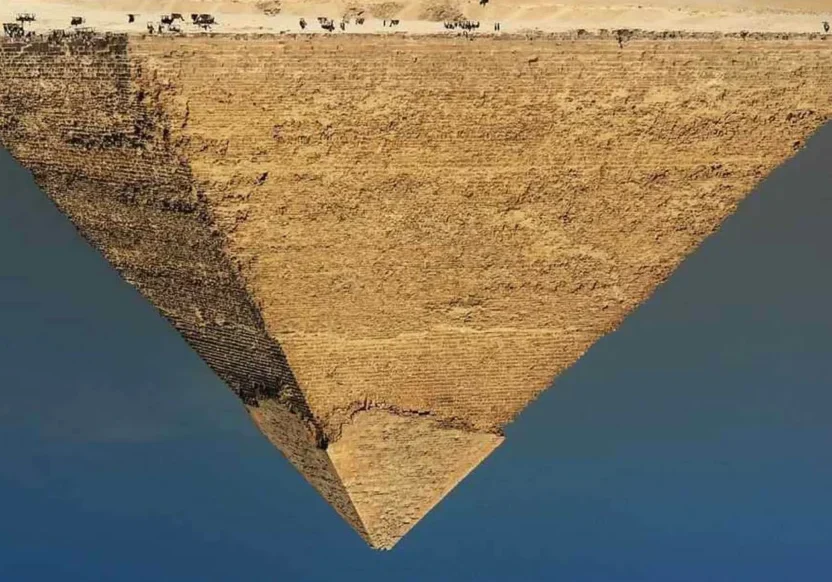 Aerial view of a pyramid in a desert with a clear blue sky.
